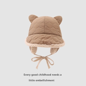 Detail of winter baby hat featuring quilted fabric, warm faux fur lining, and bear ears