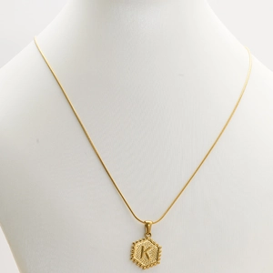 18K gold-plated hexagon initial K pendant on snake chain worn on a white mannequin