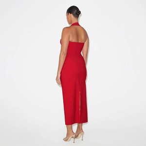 Detail view of the halter backless design and slit hem on this red midi dress