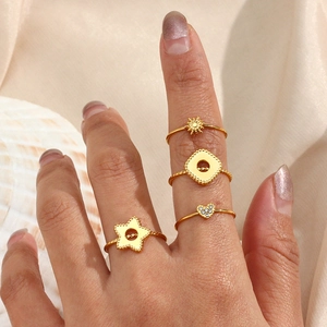 Macro shot of 18K gold plated ring set with heart and star charms on hands