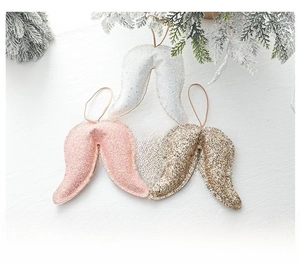 Three sequined angel wing Christmas ornaments in white, pink, and gold colors with hanging strings