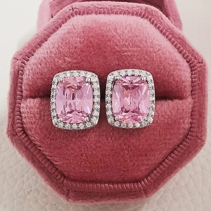 Macro shot of cushion-cut pink zircon earrings with halo diamonds in a pink velvet box