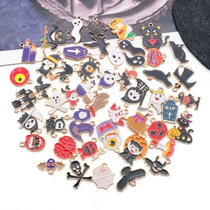 Collection of mixed Halloween charms featuring pumpkins, ghosts and black cats on white surface