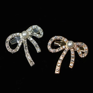 Elegant bow-shaped brooch with pearls and crystals in gold and silver plating