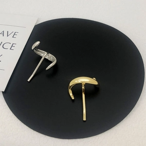 Detail showing sleek silver and gold metal hair clips on a minimalist black stand