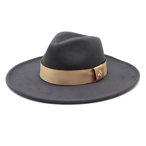 Detail of dark grey wool felt fedora featuring gold ribbon and bee metal emblem