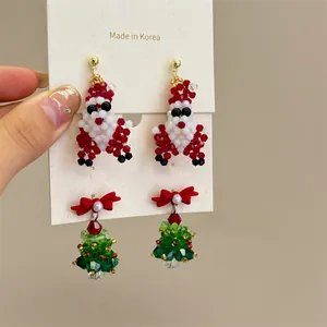 Detailed view of handmade beaded Christmas tree and Santa Claus stud earrings set