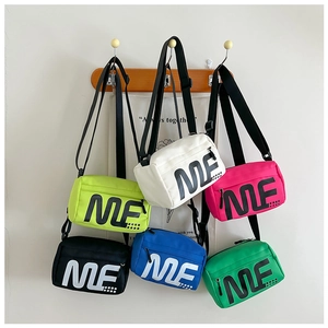Détail de sacs bandoulière colorés pour enfants avec imprimé 'ME' et bandoulières