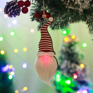 Close-up of glowing Christmas forest gnome pendant with LED light and red stripes