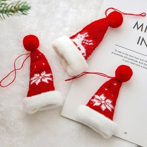 Mini-Strickmützen als Weihnachtsdeko mit roten Rentier- und Schneeflockenmustern