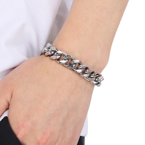 Gros plan d'un bracelet gourmette en acier inoxydable poli argenté sur un poignet