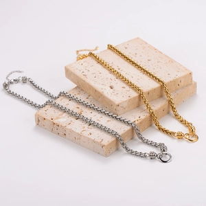 Minimalist 18k gold and silver hollow circle necklaces on decorative stone blocks