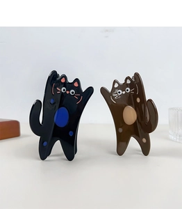 Detailed view of cat-shaped acetate hair clips in glossy black and brown colors