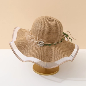 Détail du chapeau de soleil montrant dentelle, fleurs en tissu et perles