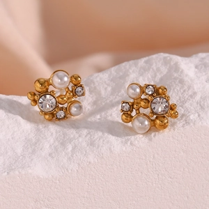 Detailed macro view of irregular cluster earrings with gold finish, pearls, and crystals