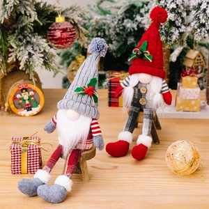 Detail of knit Christmas gnomes featuring grey braided hat and red pom-pom design