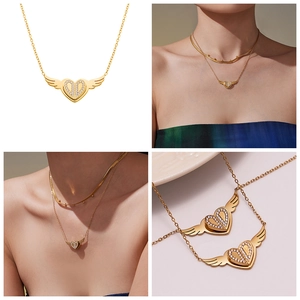 Detailansicht der goldenen Herz-Engelsflügel-Halskette mit Strass auf Model und weißem Grund