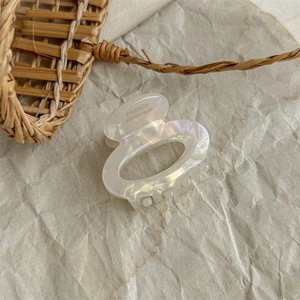 Detail of handmade pearlescent acetate hair claw clip with France engraved text