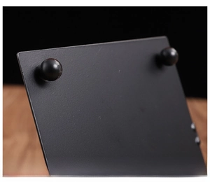Detail of matte black metal tissue holder with elevated ball feet for moisture protection