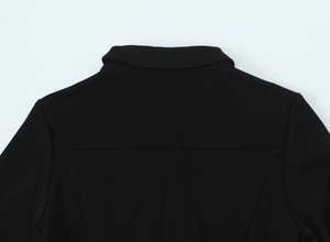 Détail du tissu en crêpe noir et des coutures précises sur l'encolure arrière de la robe