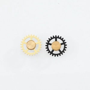 Steampunk gear stud earrings in matte gold and black metal finish on white background