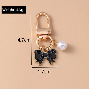Detail view of pearl bow keychain with precise 4.3g weight and size measurements