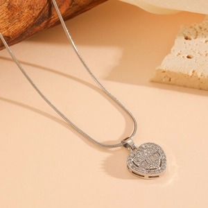 Vue détaillée du pendentif cœur serti de cristaux sur une chaîne serpent argentée