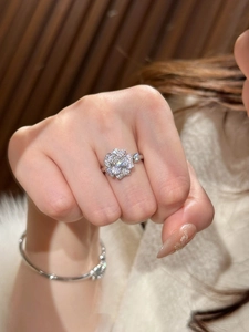 Detailed view of camellia flower zircon ring and slender bracelet on model hand