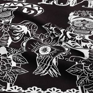 Detailed macro view of black and white skull and rose pattern on woven fabric tapestry