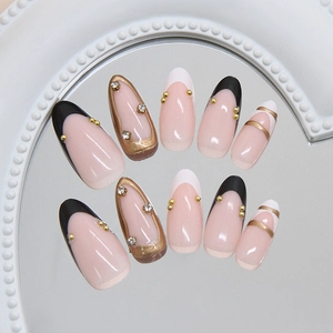 French black and white press-on nails with 3D gold accents and rhinestones on mirror base
