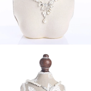 Macro view of a pearl necklace with a detailed silver flower pendant and rhinestones