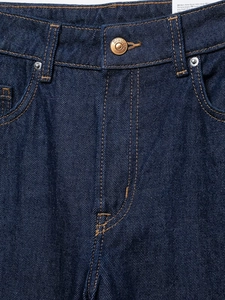 Detalle de los vaqueros azul oscuro de tiro alto con costuras en contraste naranja