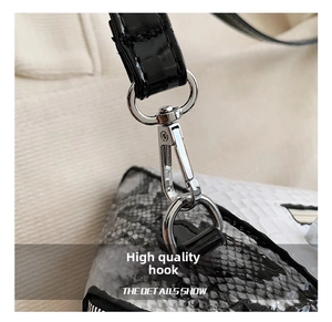 Macro detail of silver polished metal hook on snakeskin texture and white woven handbag