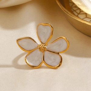 Elegant white enamel flower ring with golden edges displayed on soft beige silk background