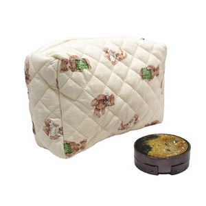 Quilted beige cosmetic bag with cartoon bear pattern and zipper on white background
