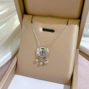 Macro shot of silver longevity lock pendant with Fu character and bells in jewelry box