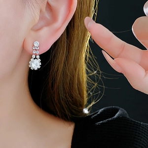 Close-up of sparkling silver teardrop earrings with cubic zirconia on model ear