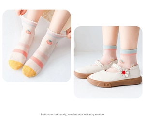 Détail de chaussettes bébé en coton mesh rose avec motifs fraises et fleurs pour l'été