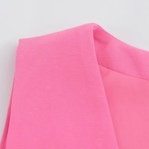 Détail macro du tissu tissé rose vif de qualité et des coutures soignées du gilet d'été