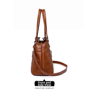 Vue latérale du sac fourre-tout en cuir marron avec structure en trapèze et zip métal