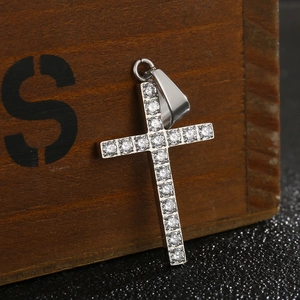 Pendentif croix en acier titane poli avec cristaux CNC sur une boîte en bois