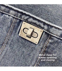 Close-up of vintage metal twist lock on blue denim crossbody bag with detailed stitching