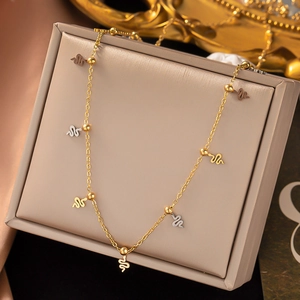 Detail view of titanium steel necklace with gold and silver snake pendants on a display box
