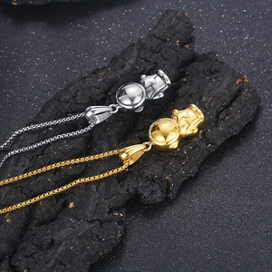 Detail of gold and silver astronaut pendants with box chains on rustic wood texture