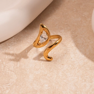 Detailed view of a gold-tone wavy irregular ring featuring a pear-shaped zircon stone