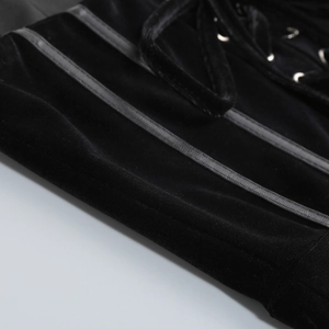 Detail of black velvet corset with leather trim, metal eyelets and lace-up straps