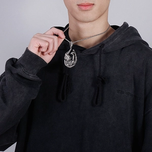 Detailed view of silver dragon pendant necklace in vintage stainless steel on male model