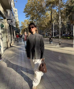 Détail d'un blazer gris à carreaux avec revers asymétrique et bouton pour femmes