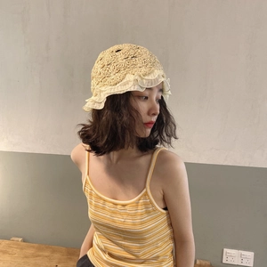Detail of hand-woven straw hat featuring white lace ruffles and intricate crochet texture