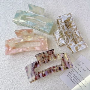 Set of four large acetate hair claws with marble patterns and metal springs